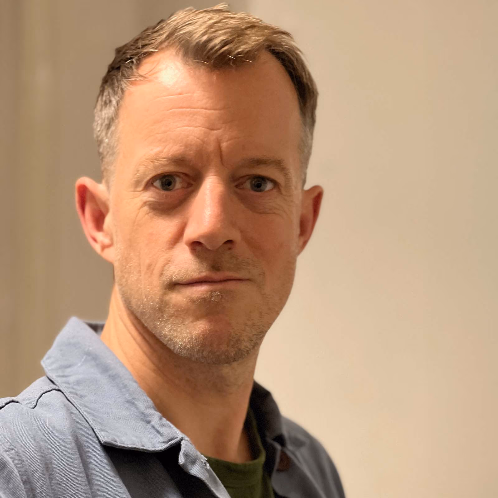Julius Honnor, in a blue work jacket, looking at the camera