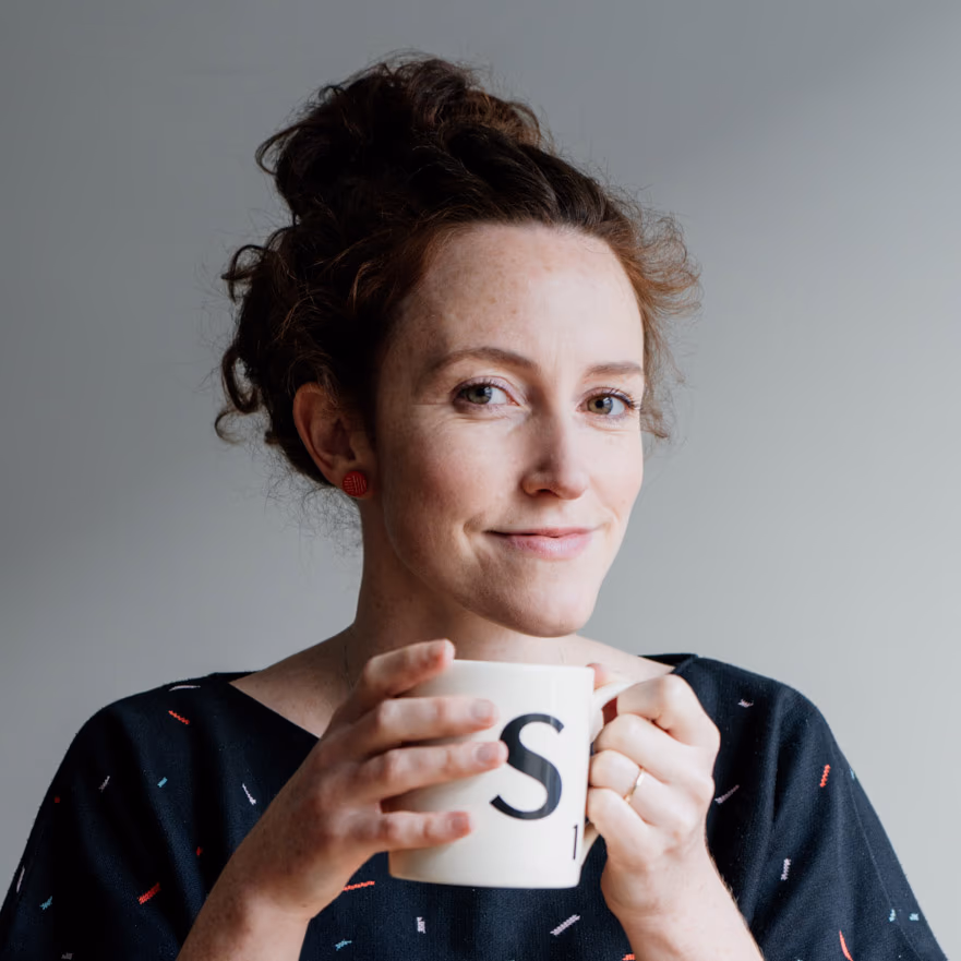 Sarah Oxley, smiling, holding a mug